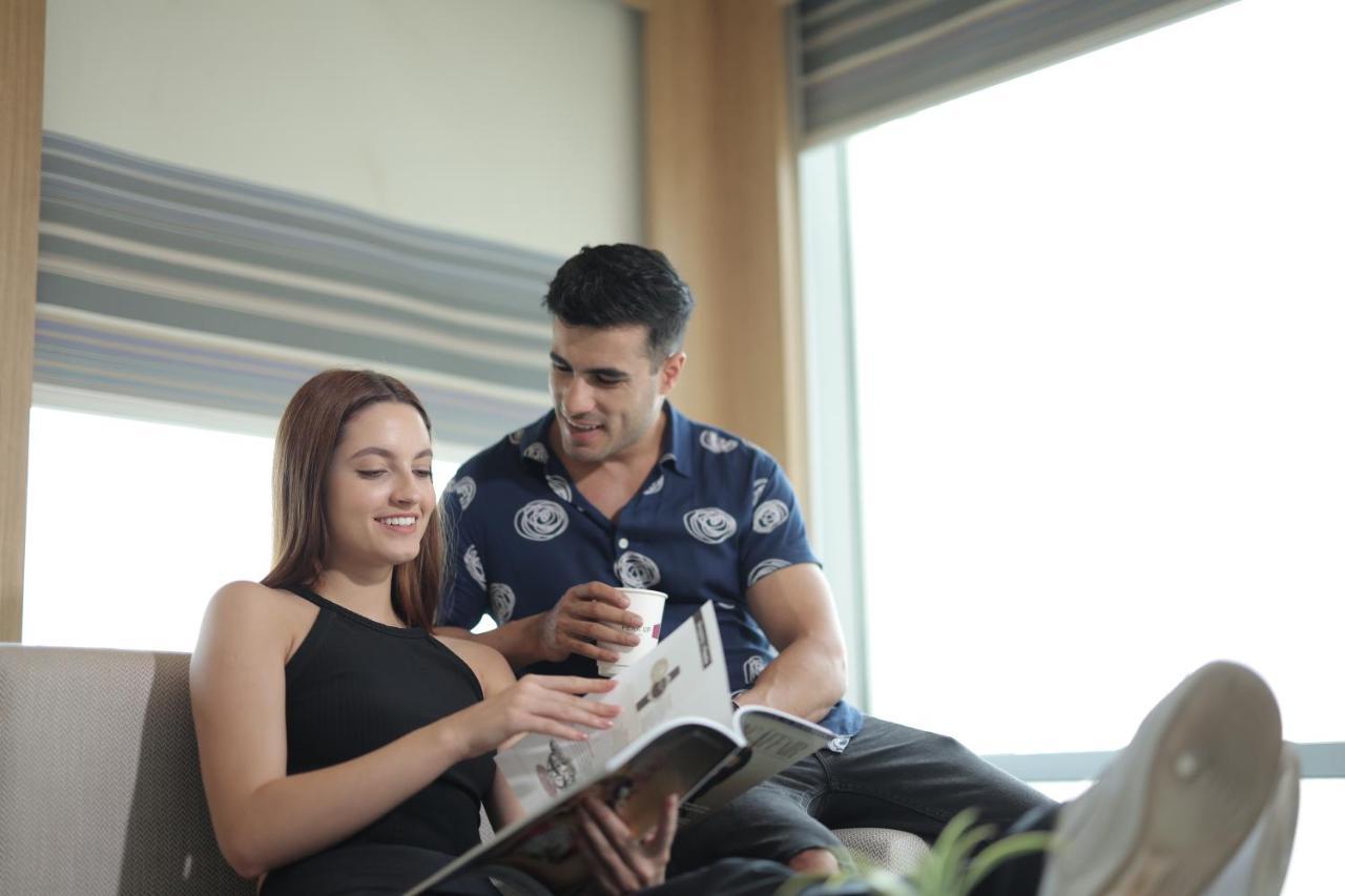 فندق ألوفت نيودلهي آيروسيتي المظهر الخارجي الصورة A couple reading a magazine